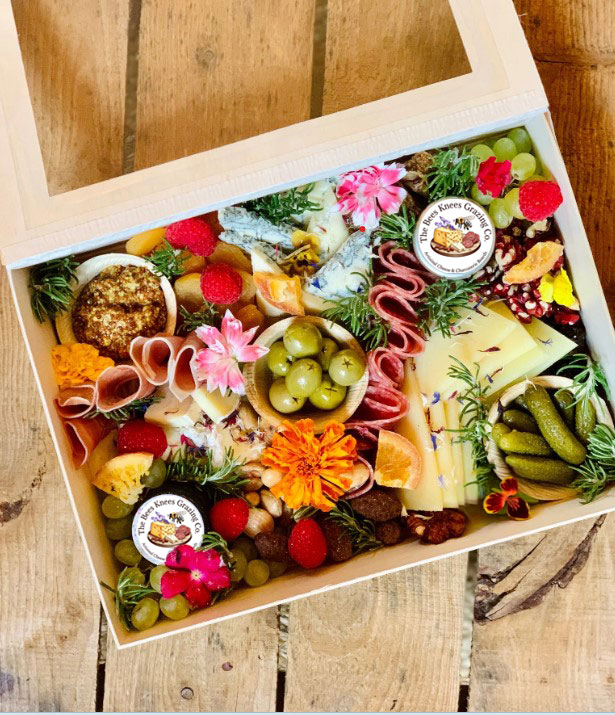 Charcuterie, cheese, honey, jam, grapes in a delivery box 